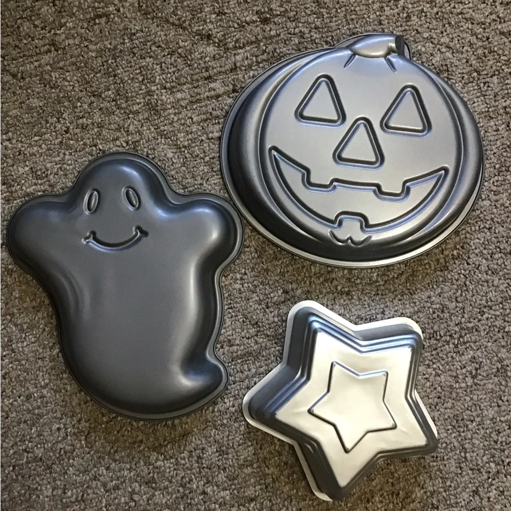 A total of 3 cake pans one star, one ghost , one pumpkin